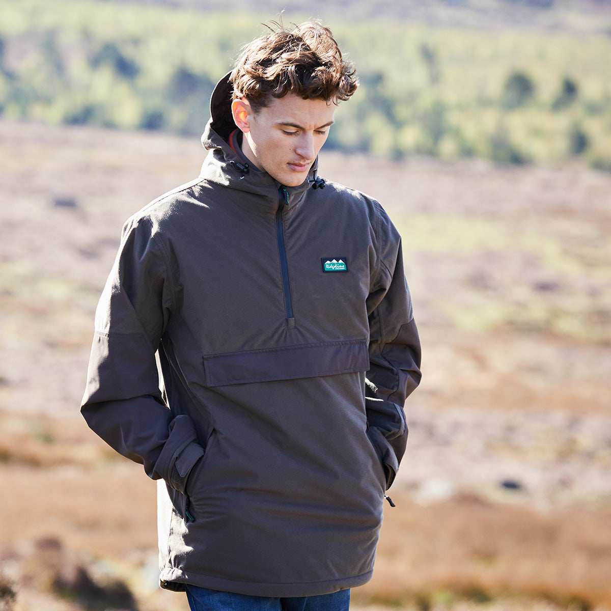 Person wearing a brown jacket with a Ridgeline Clothing brand logo in an outdoor setting