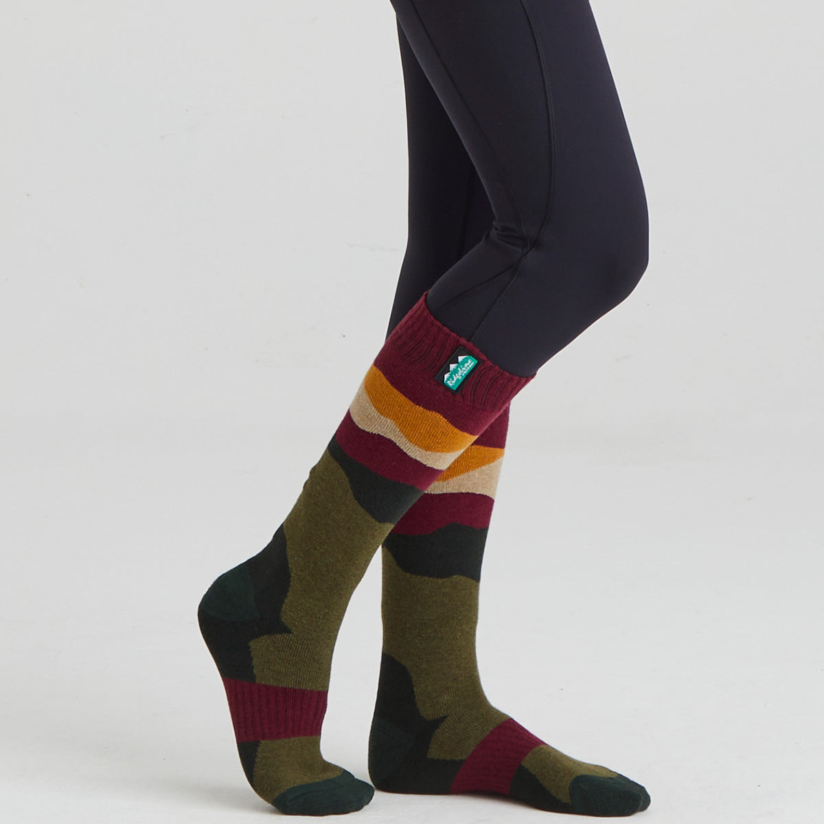 Colorful patterned socks worn with leggings on a white background