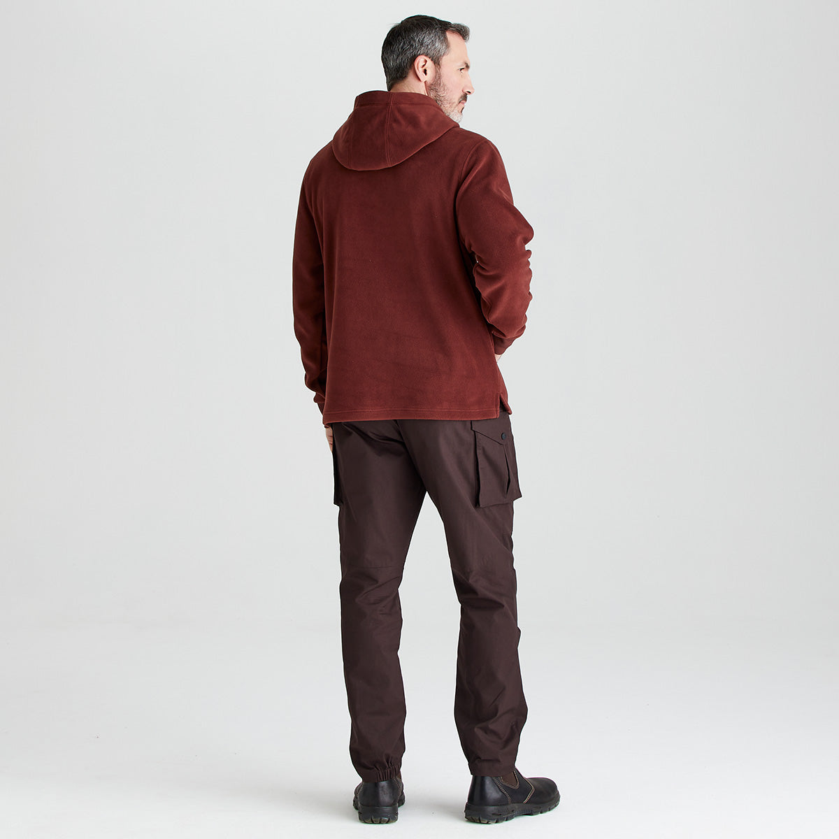 Man wearing a red jacket and pants on a light gray background