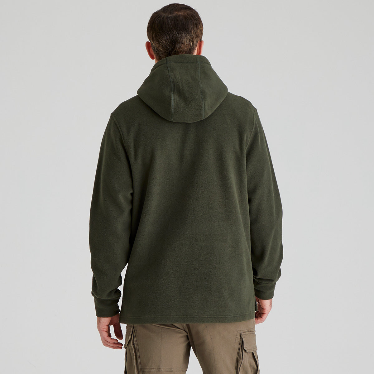 back view of person wearing a green hoodie from behind on a light grey background