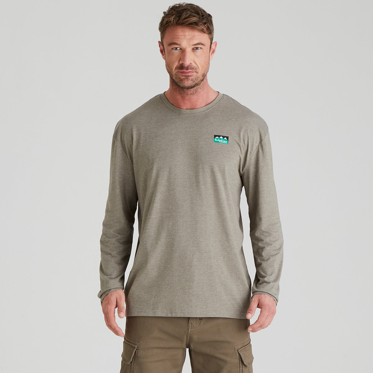 Man wearing a grey long-sleeve shirt with a Ridgeline Clothing logo on a light grey background