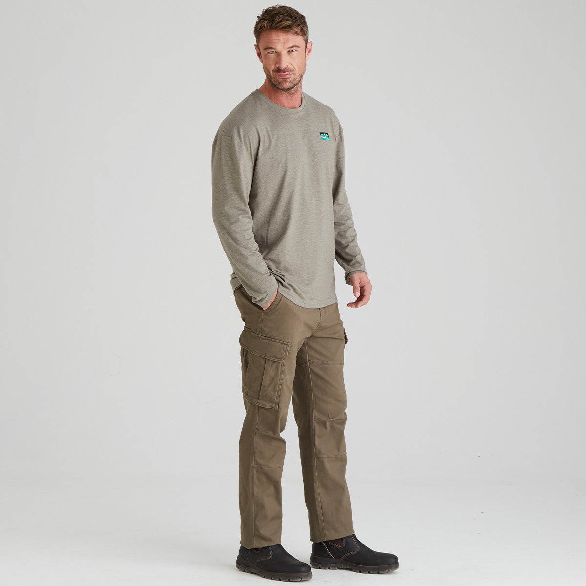 Man wearing a long-sleeve shirt and cargo pants on a white background