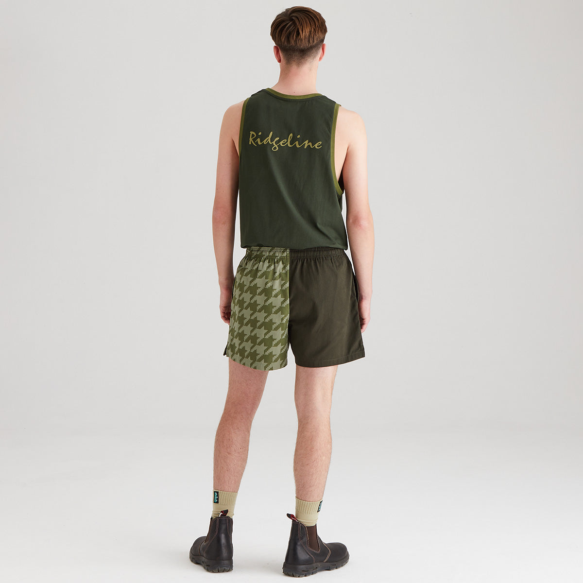 Person wearing a green tank top and shorts with 'Ridgeline' branding on a white background