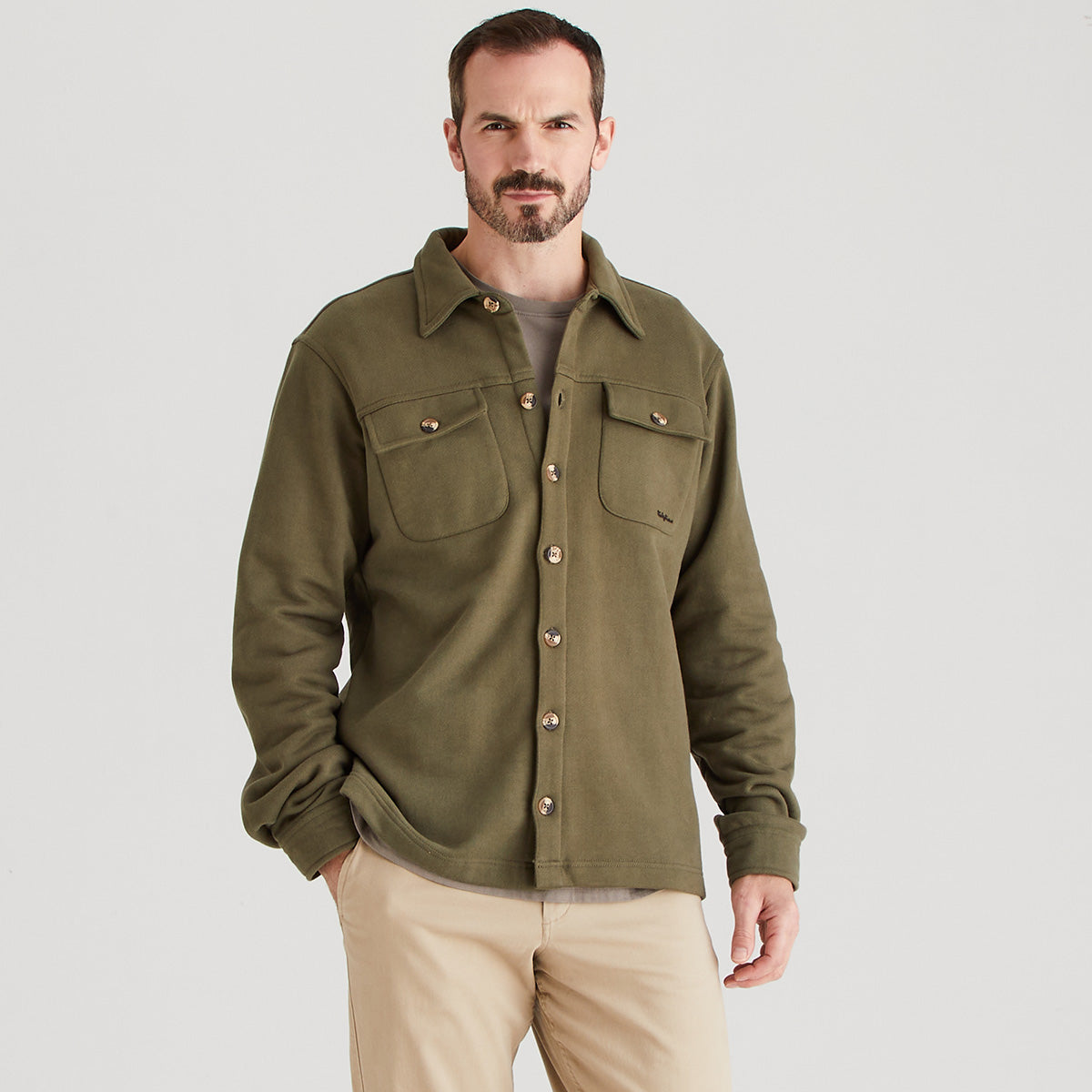 Man wearing a green jacket on a gray background