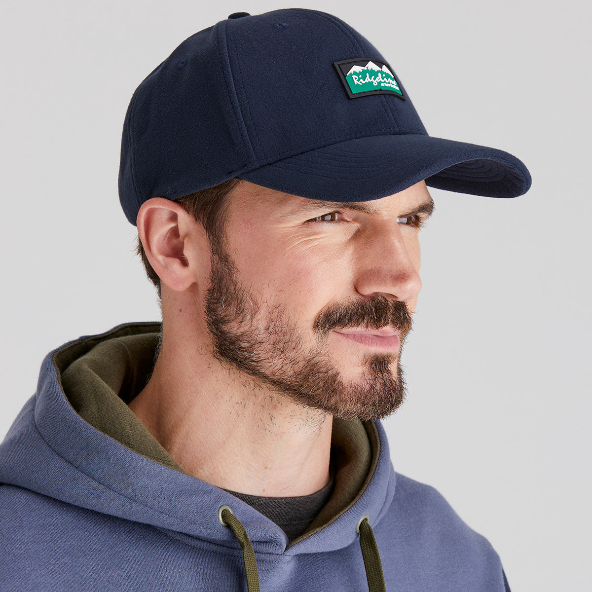 Man wearing blue cap in studio setting