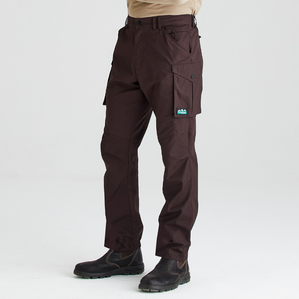 Brown cargo work trousers with multiple utility pockets, front angled view, worn with black work boots on a light background.