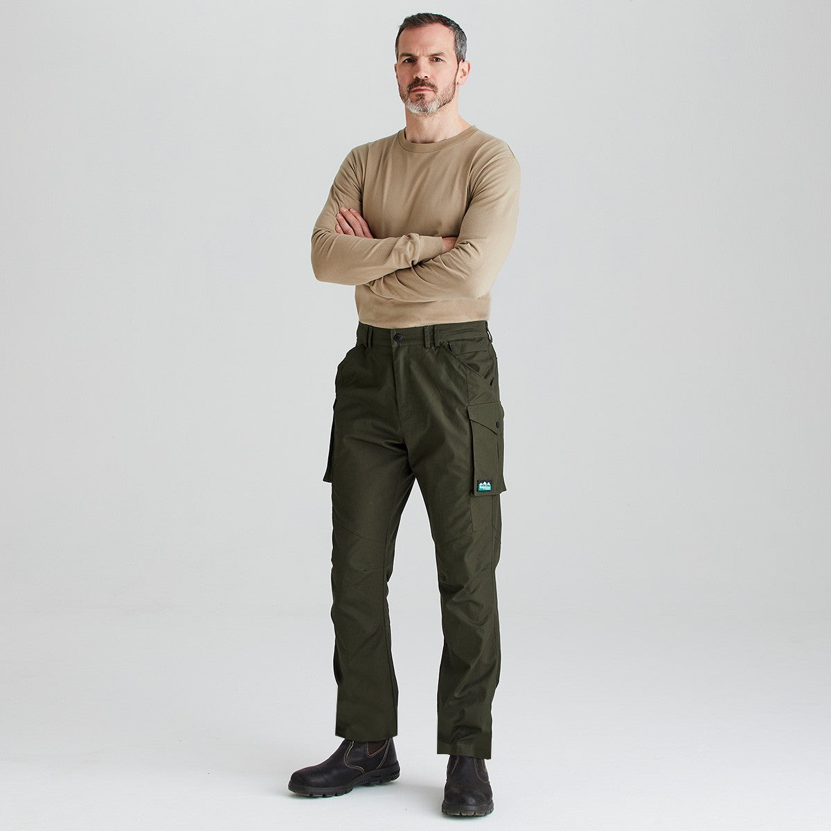Olive green cargo work trousers with utility pockets, full-length front view worn with black work boots.