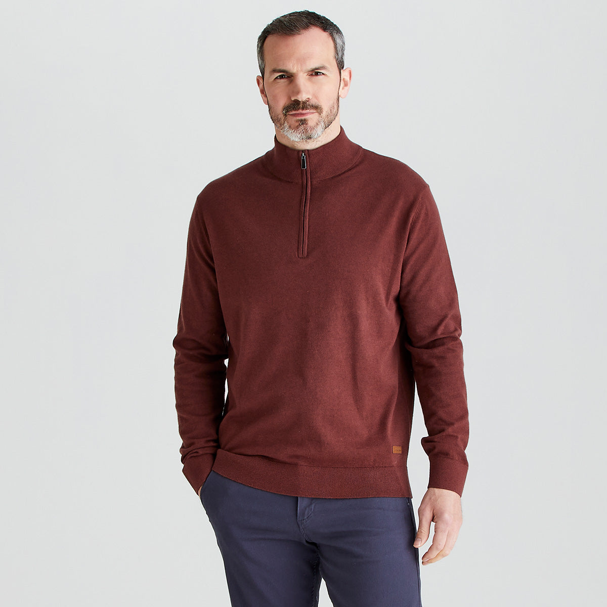 model wearing a red quarter zipper pullover in a gray background