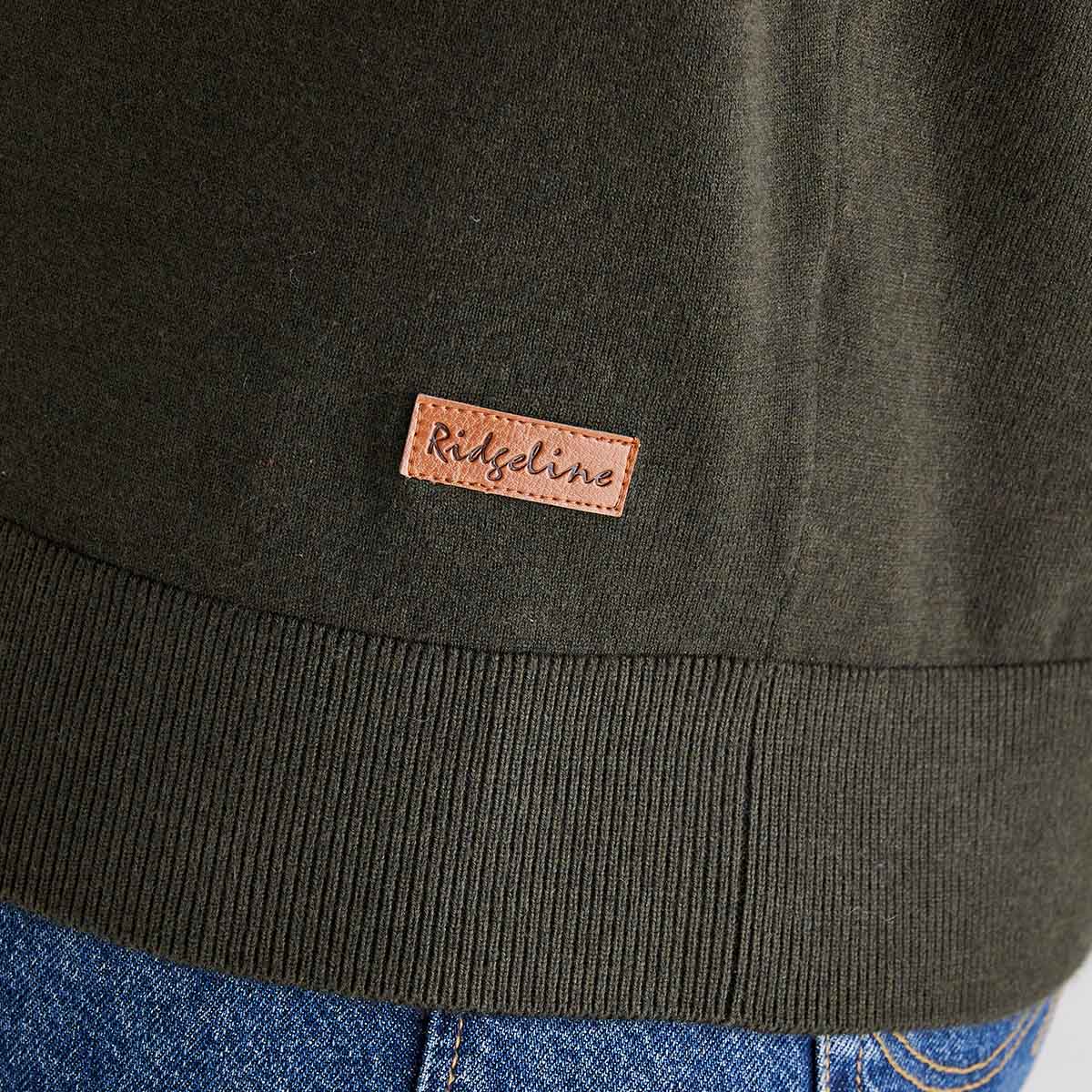 Close-up of a dark green jacket with a 'Ridgeline' brand patch on the chest.