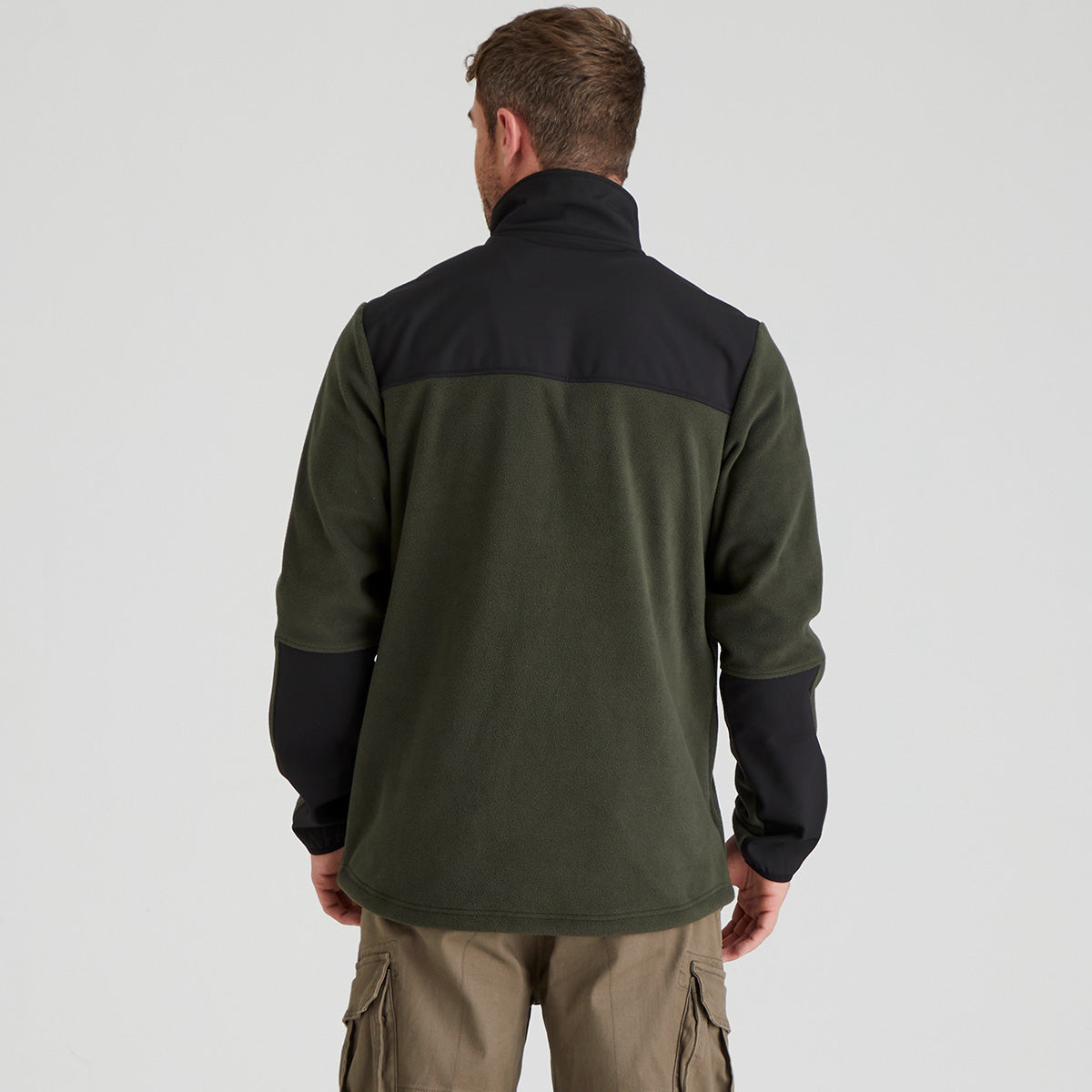 back view of Man wearing a green and black jacket on a light grey background