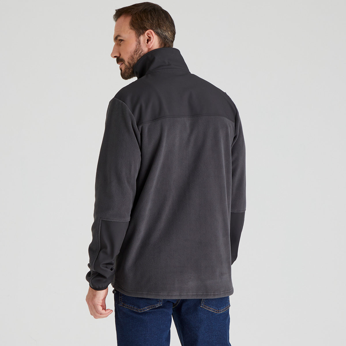 back view of Man wearing a dark grey fleece jacket on a light grey background