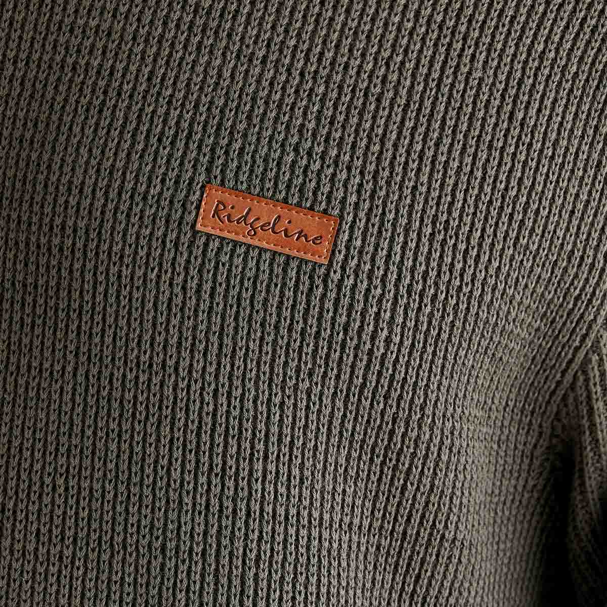 Close-up of a textured fabric with a brand label on a gray background