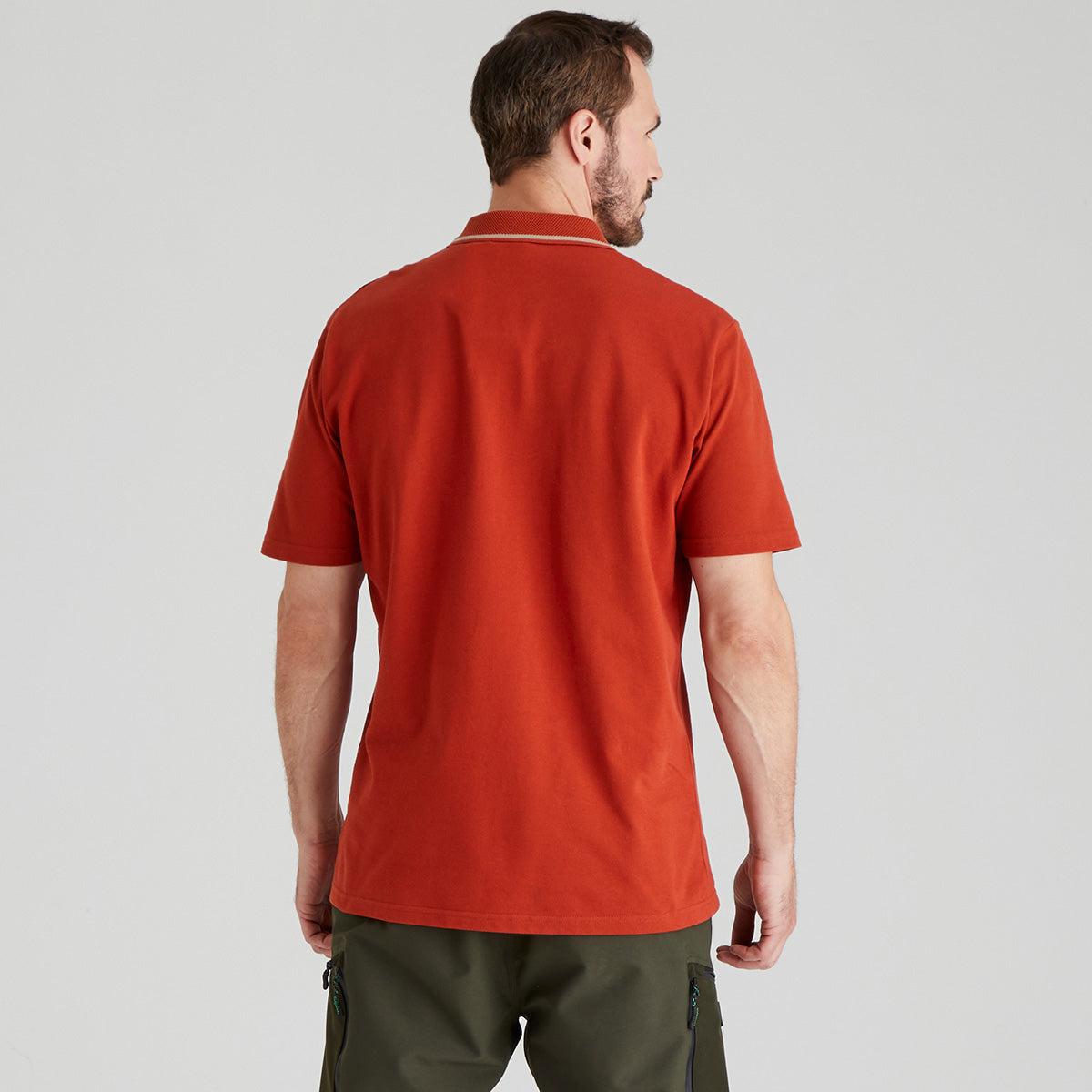 Back view of man wearing orange polo shirt