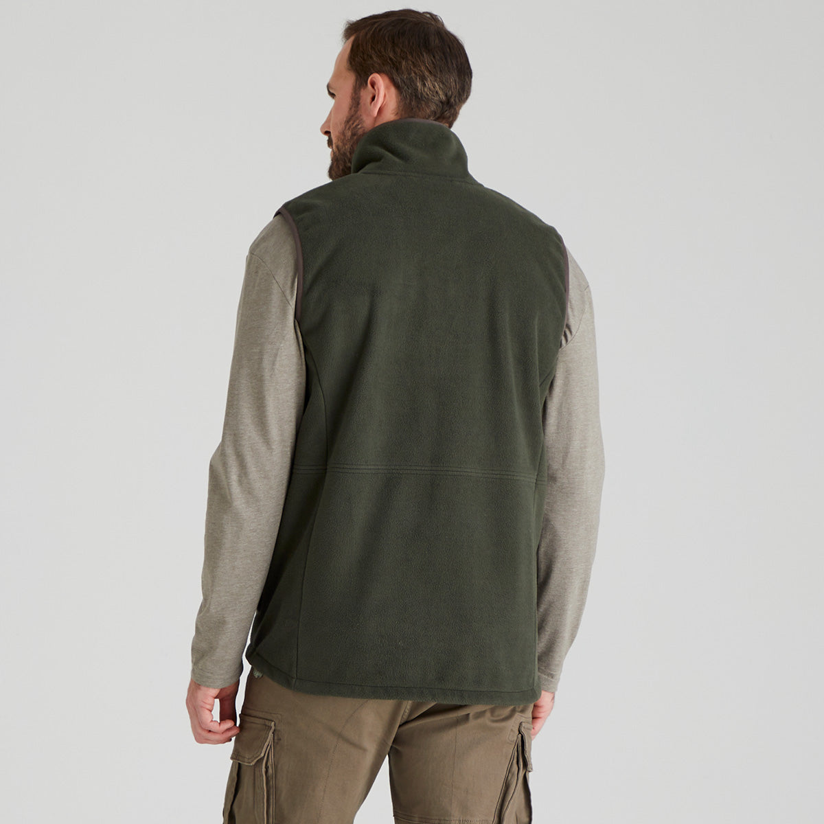 back view of man wearing a green fleece vest over a grey shirt on a white background