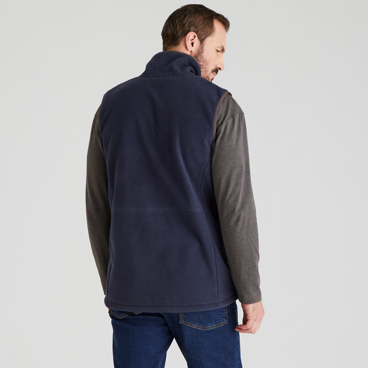 back view of Man wearing blue windproof fleece gilet with jeans