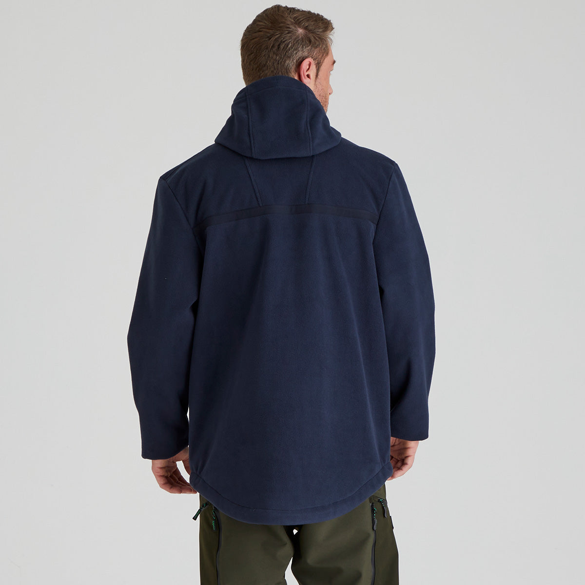 back view of man wearing a navy blue jacket on a light grey background