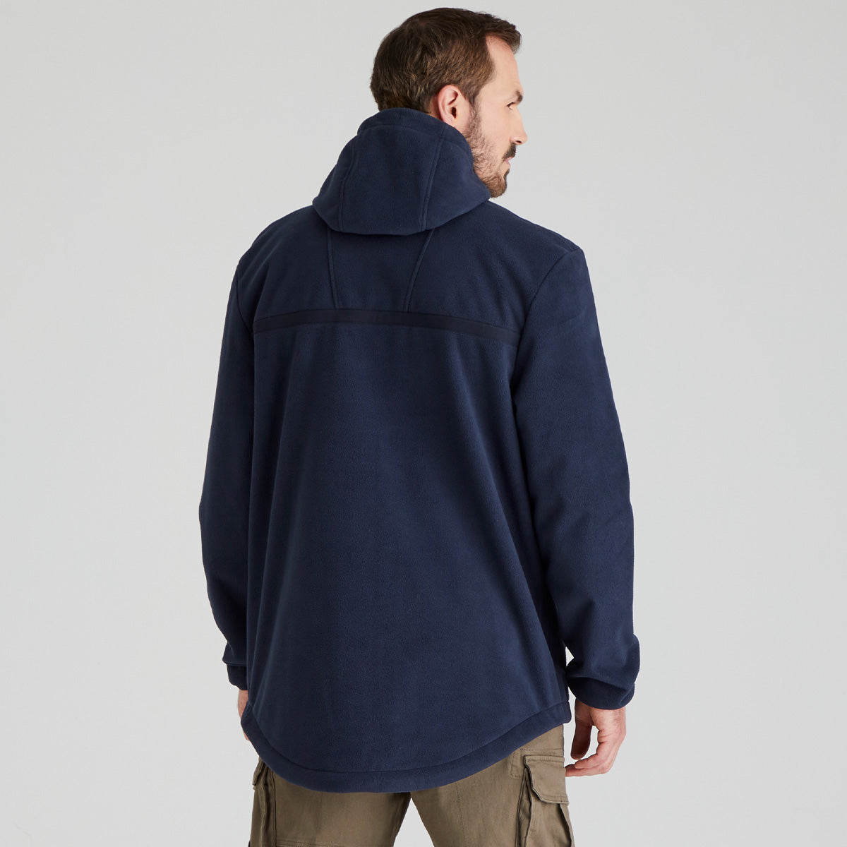 back view of man wearing a navy blue jacket on a light grey background