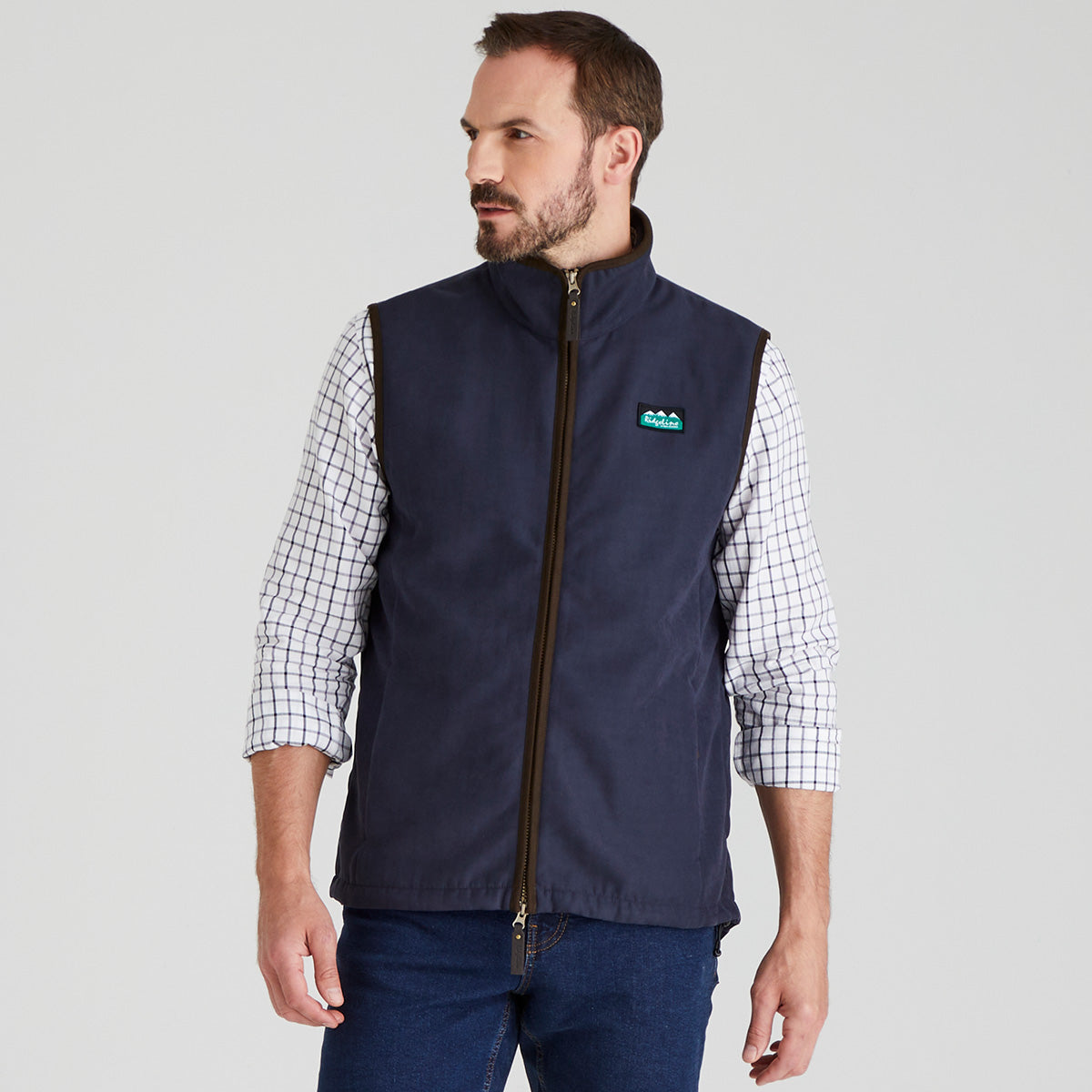 Man wearing navy windproof fleece gilet with checked shirt