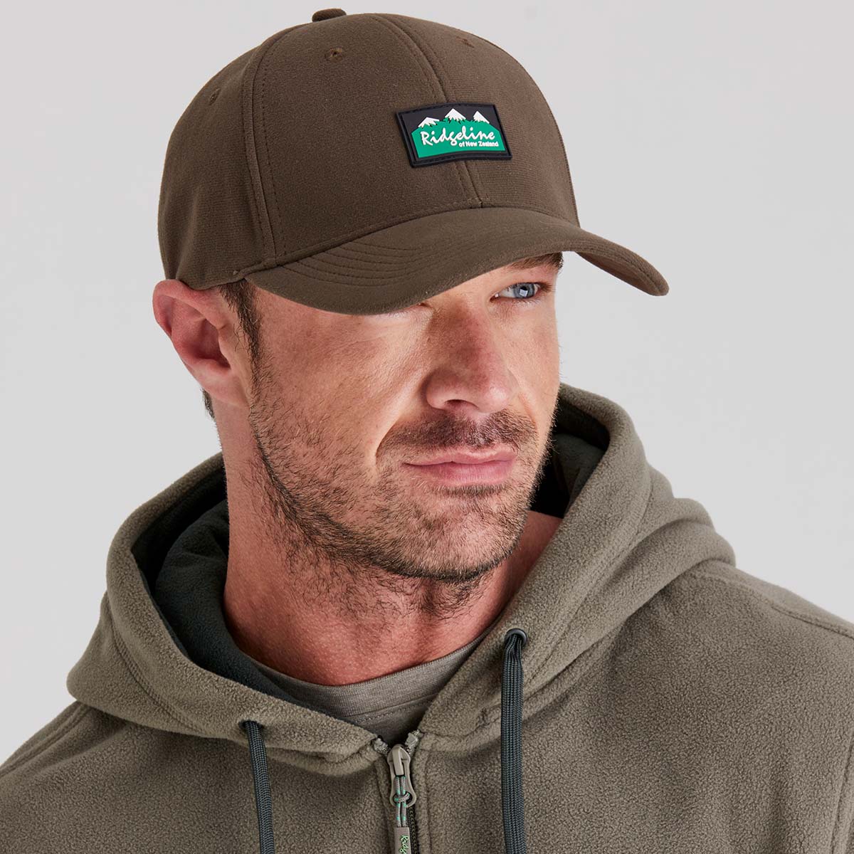Man wearing Brown fleece hat with ridgeline clothing logo on front