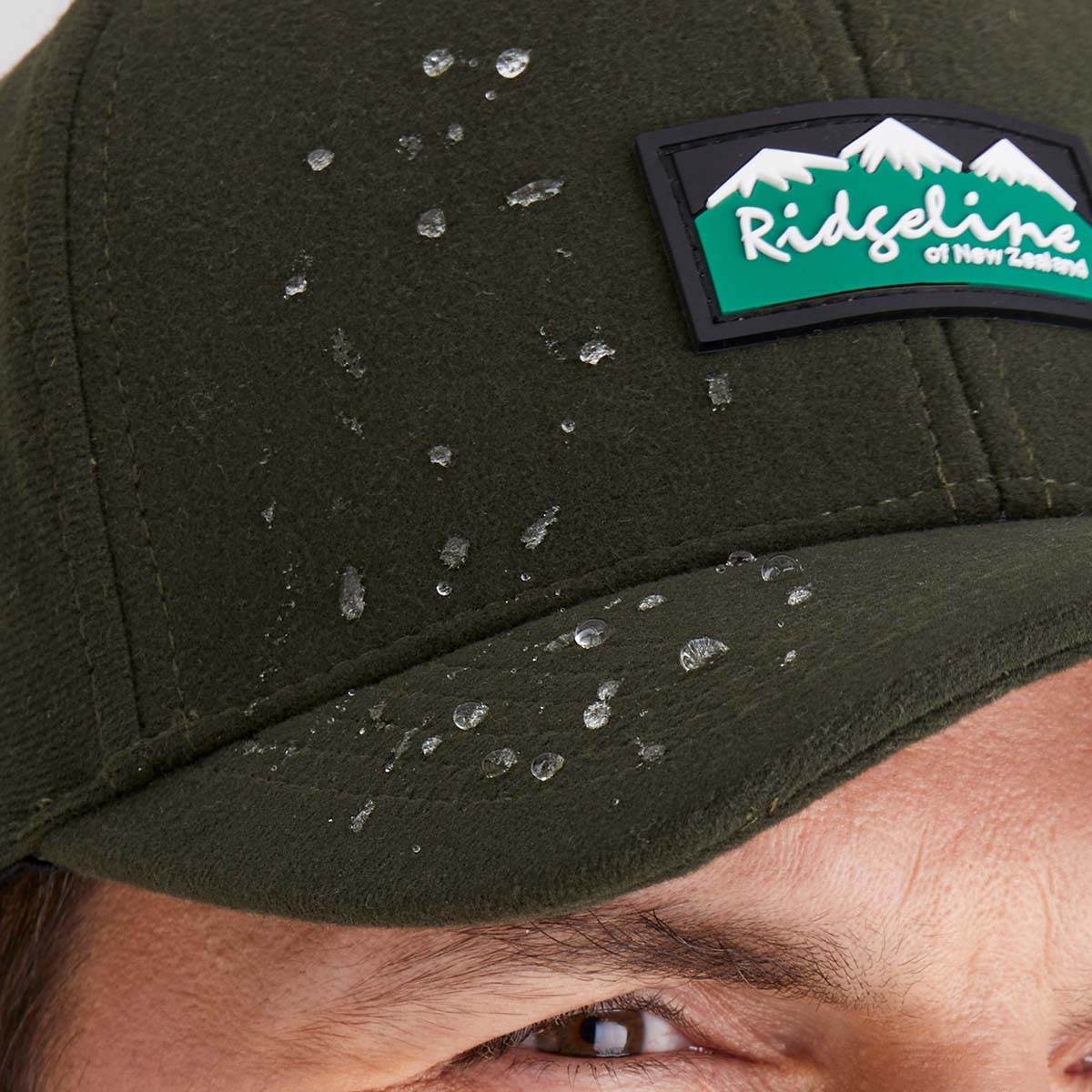 Green cap with a visible brand logo, showing water droplets on the surface.