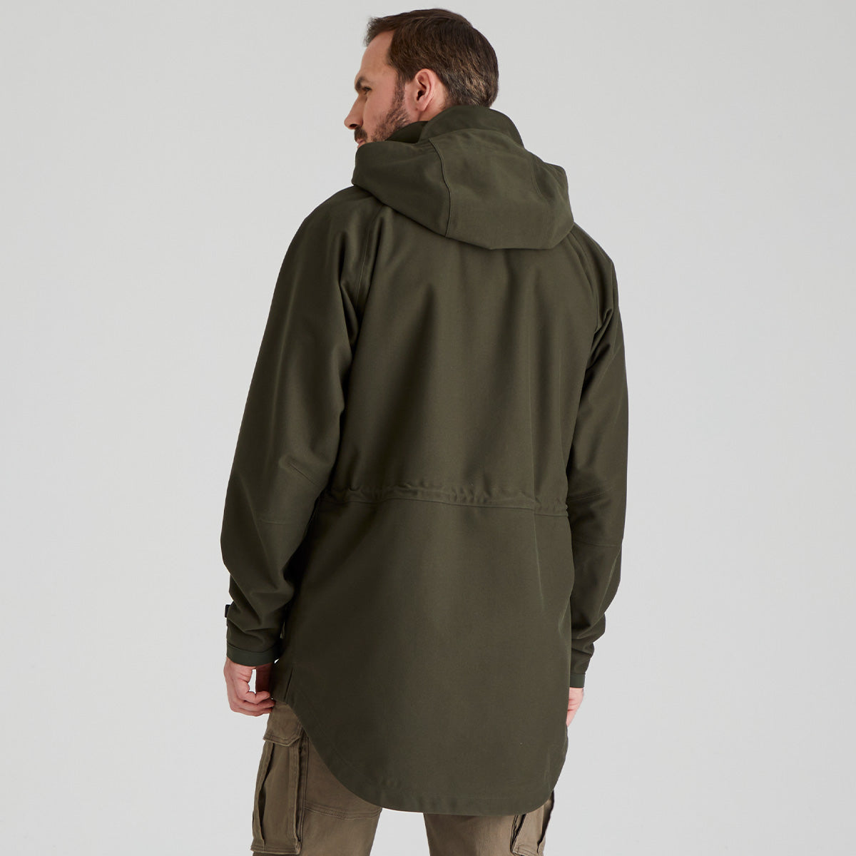 back view of man wearing a green jacket on a light grey background