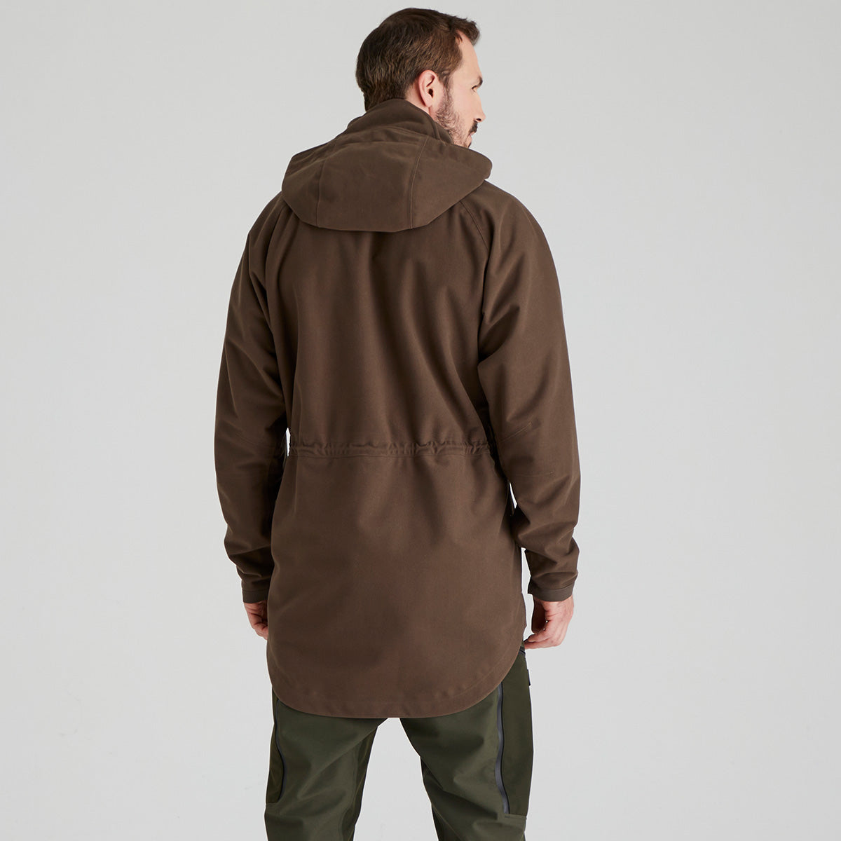 back view of man wearing a brown jacket on a light grey background