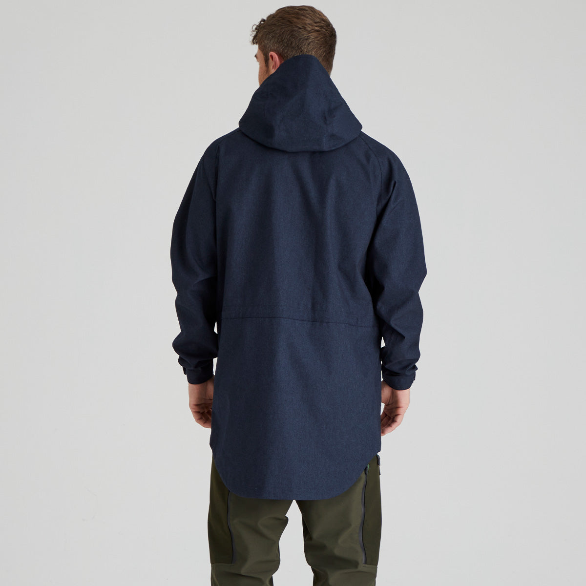 back view of person wearing a navy blue jacket on a light grey background