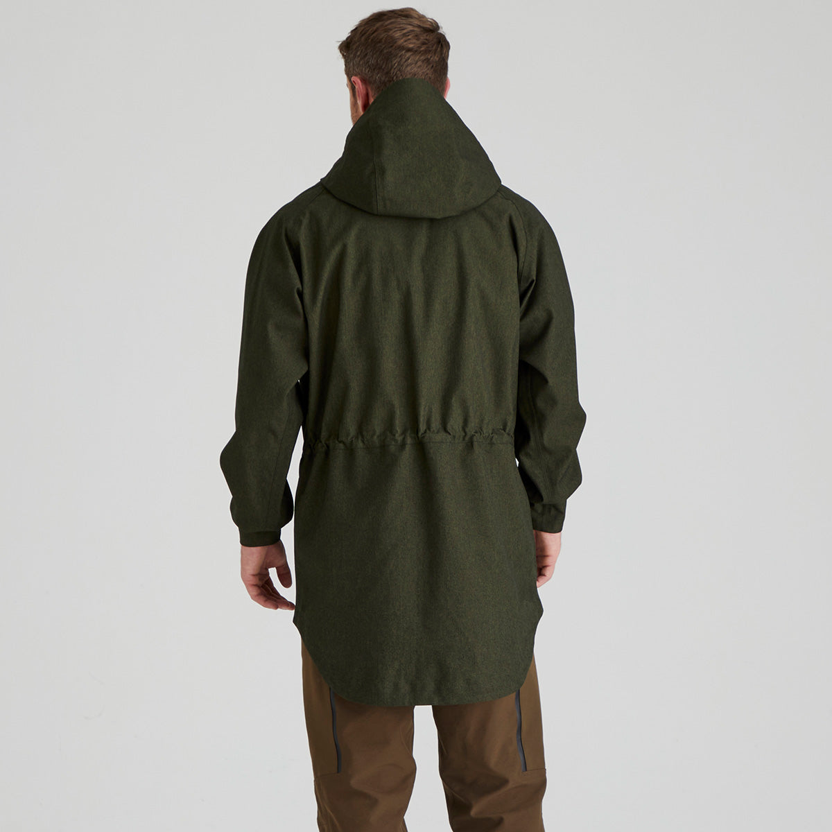 back view of man wearing a green raincoat on a light grey background