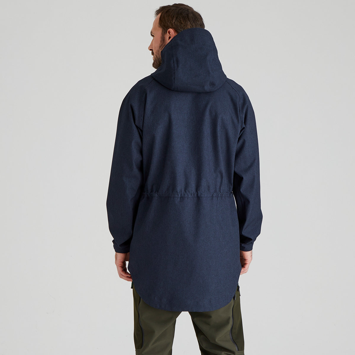 back view of man wearing a navy blue hooded jacket on a light grey background