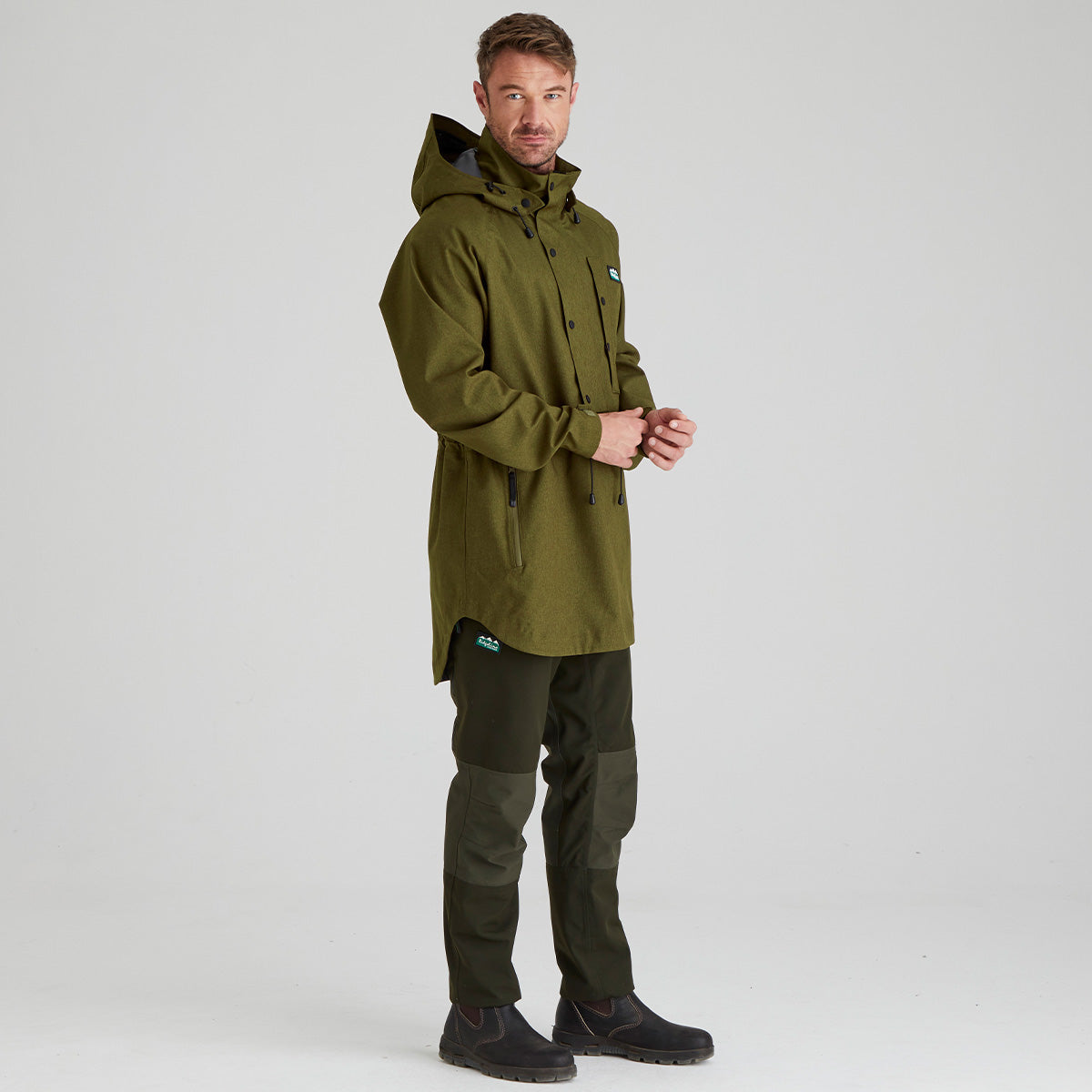 Man wearing a green watering smock and pants on a white background