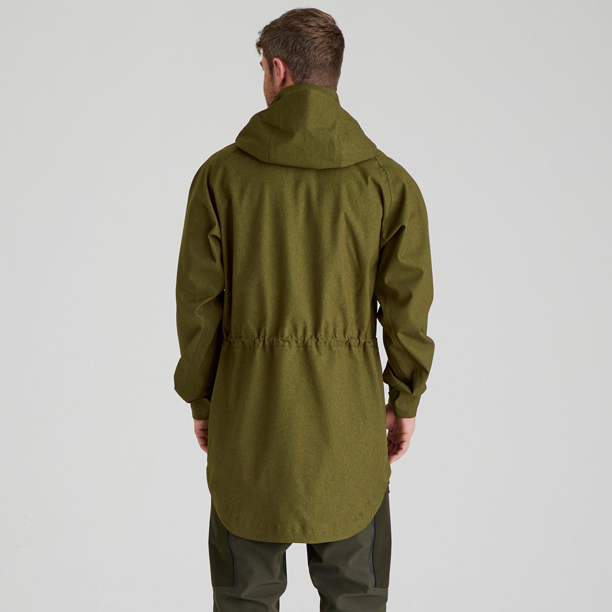 back view of man wearing a green raincoat on a light grey background