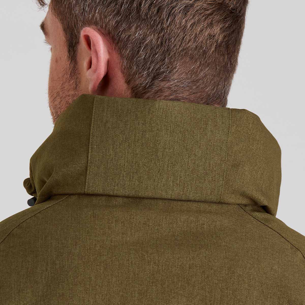 Close-up of a person wearing an olive green jacket on a light grey background