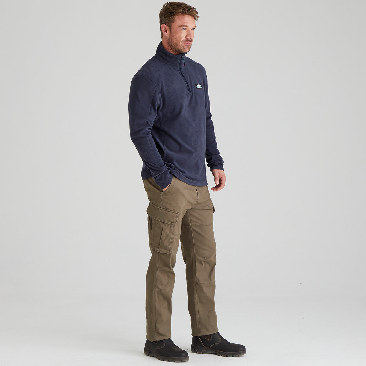 Man wearing navy fleece pullover with quarter zip. With ridgeline clothing logo