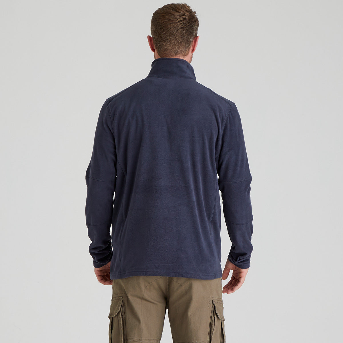 back view Man wearing navy fleece pullover with quarter zip. With ridgeline clothing logo