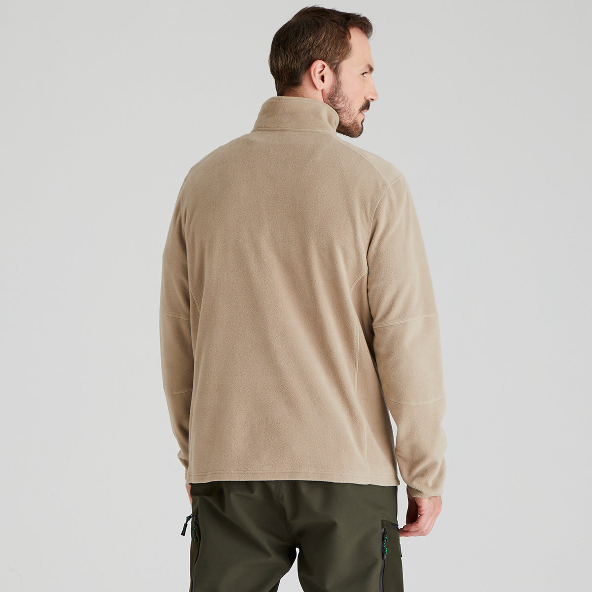 Man wearing a beige fleece pullover on a light grey background