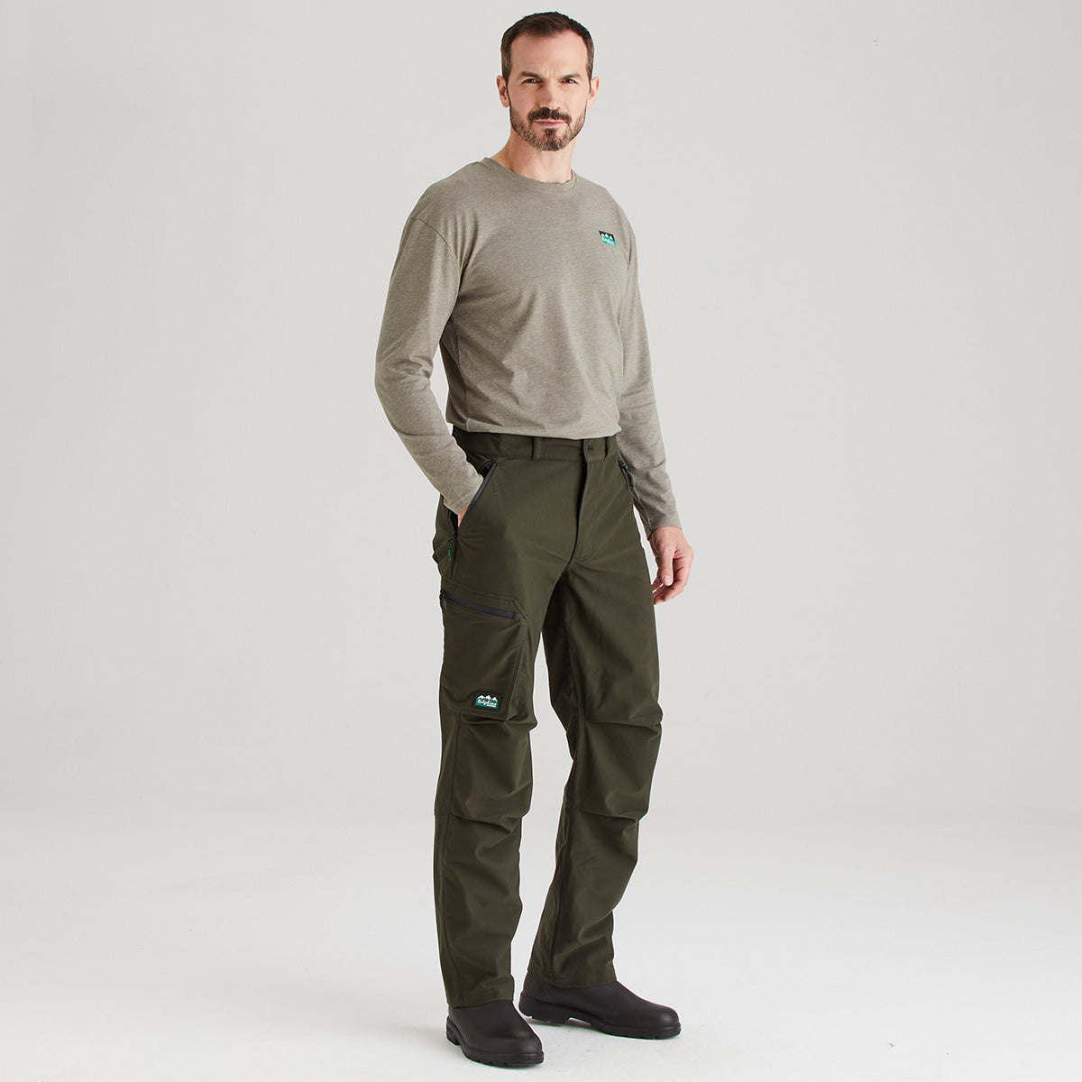 Man wearing a green long-sleeve shirt and green pants on a white background