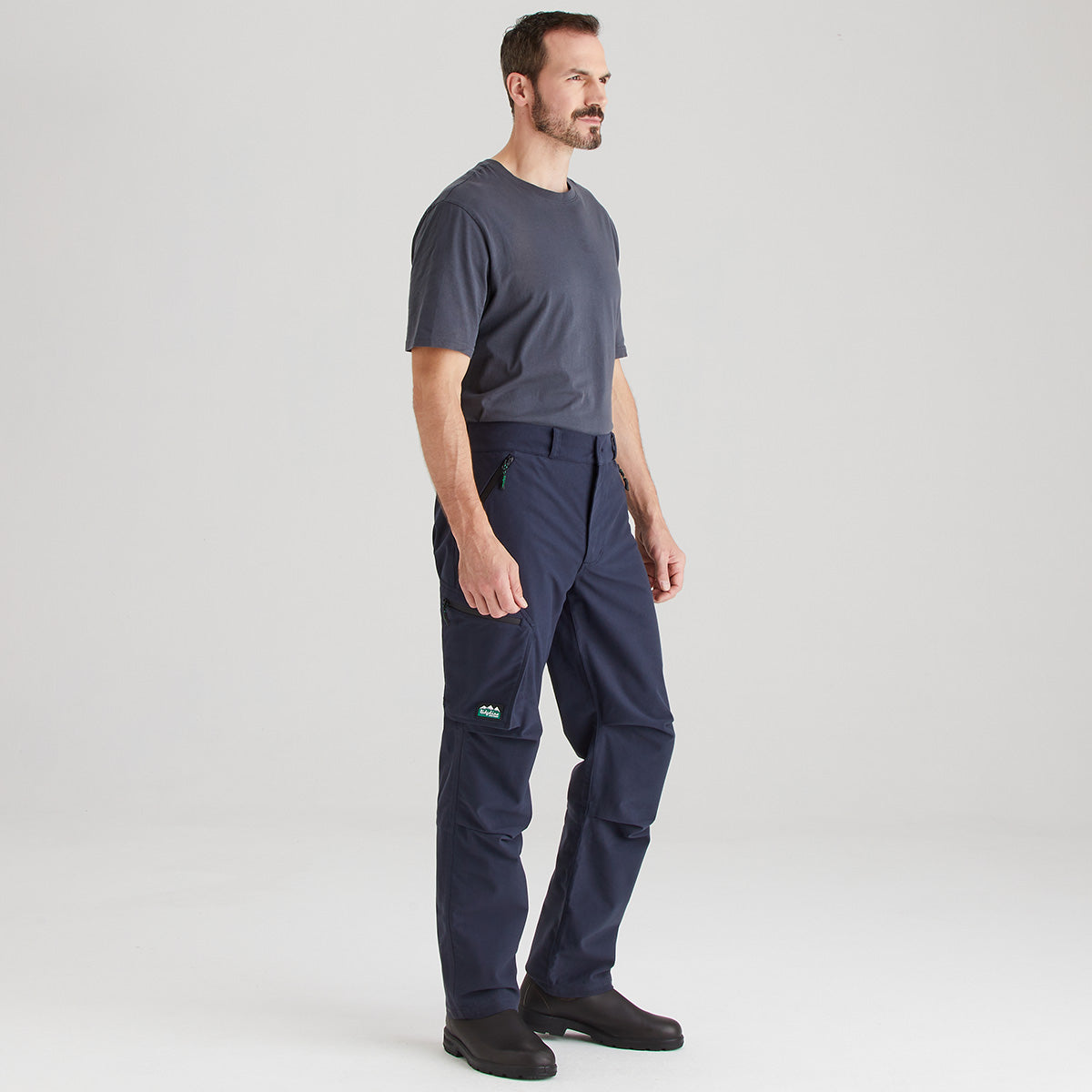 Man wearing navy pants with a small logo on a light gray background