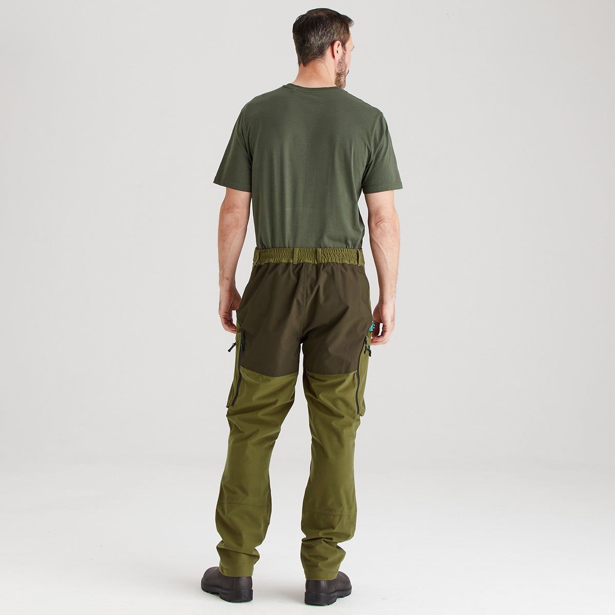 Man wearing a green outfit with cargo pants on a white background