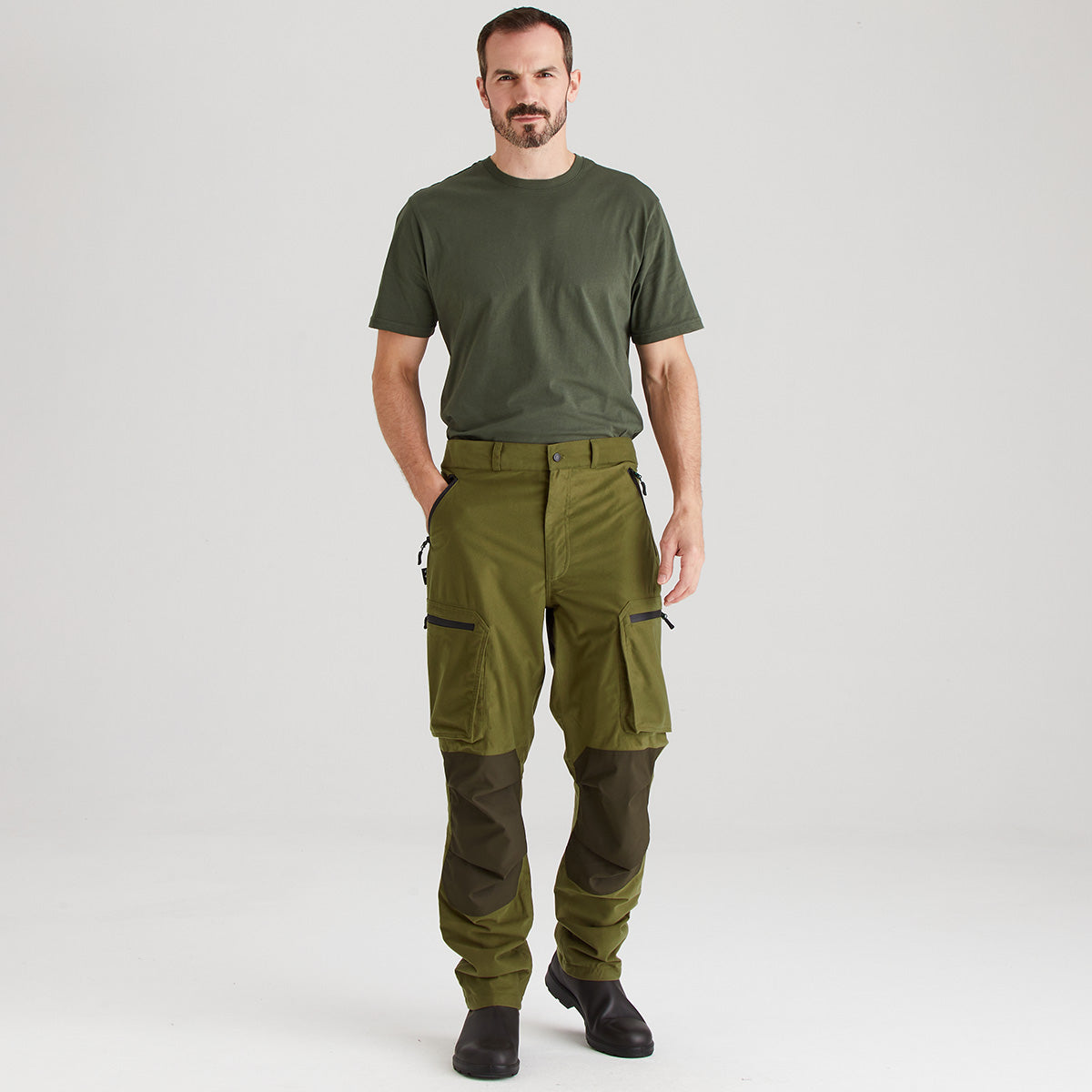 Man wearing green t-shirt and cargo pants on a white background
