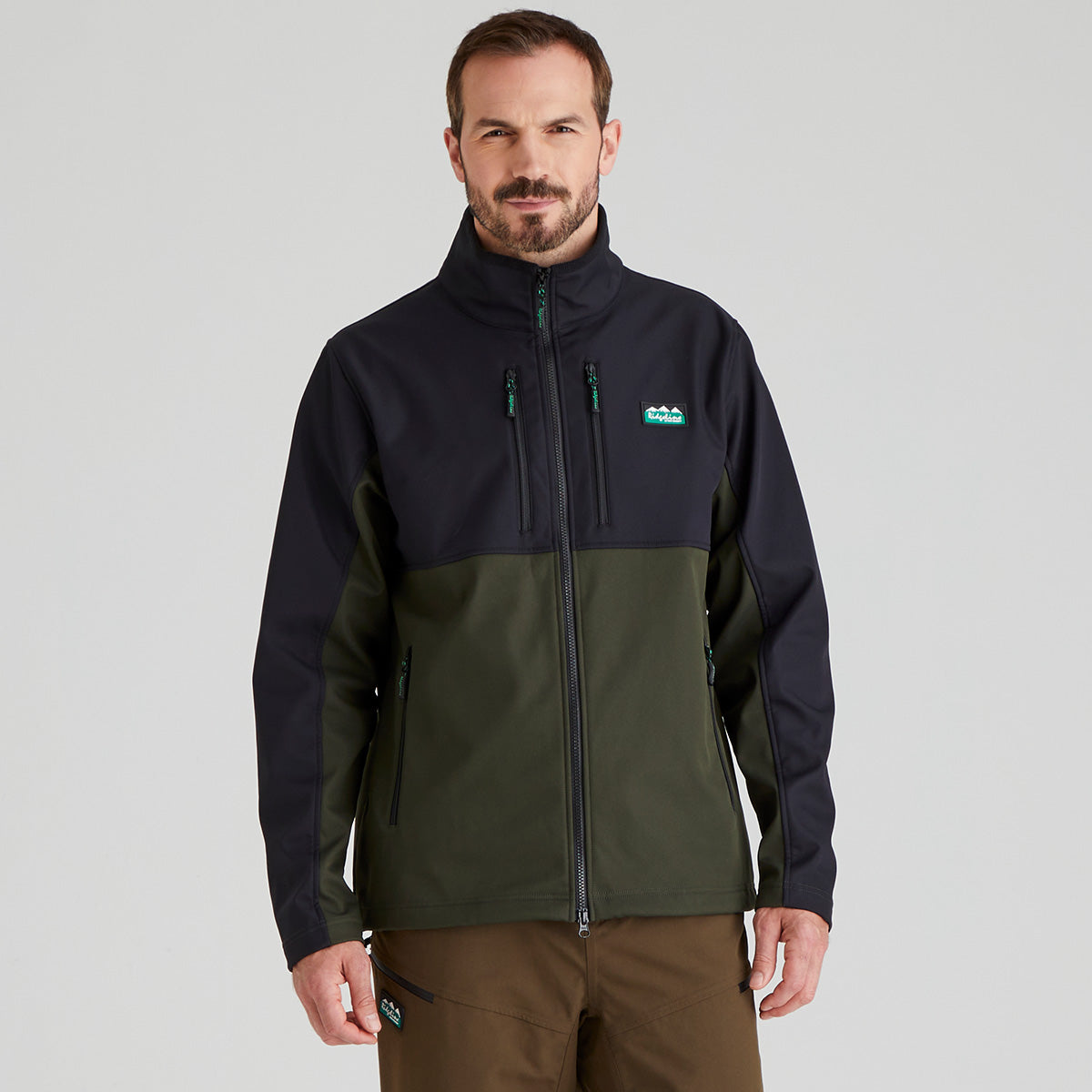 Man wearing a two-tone windproof jacket with a Ridgeline clothing brand logo on a grey background
