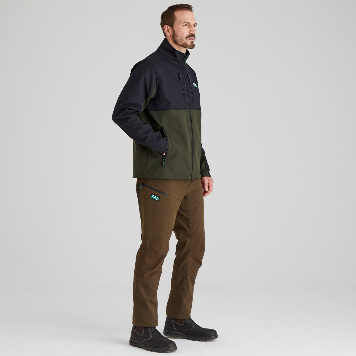 Man wearing a two-tone windproof jacket and brown pants on a white background