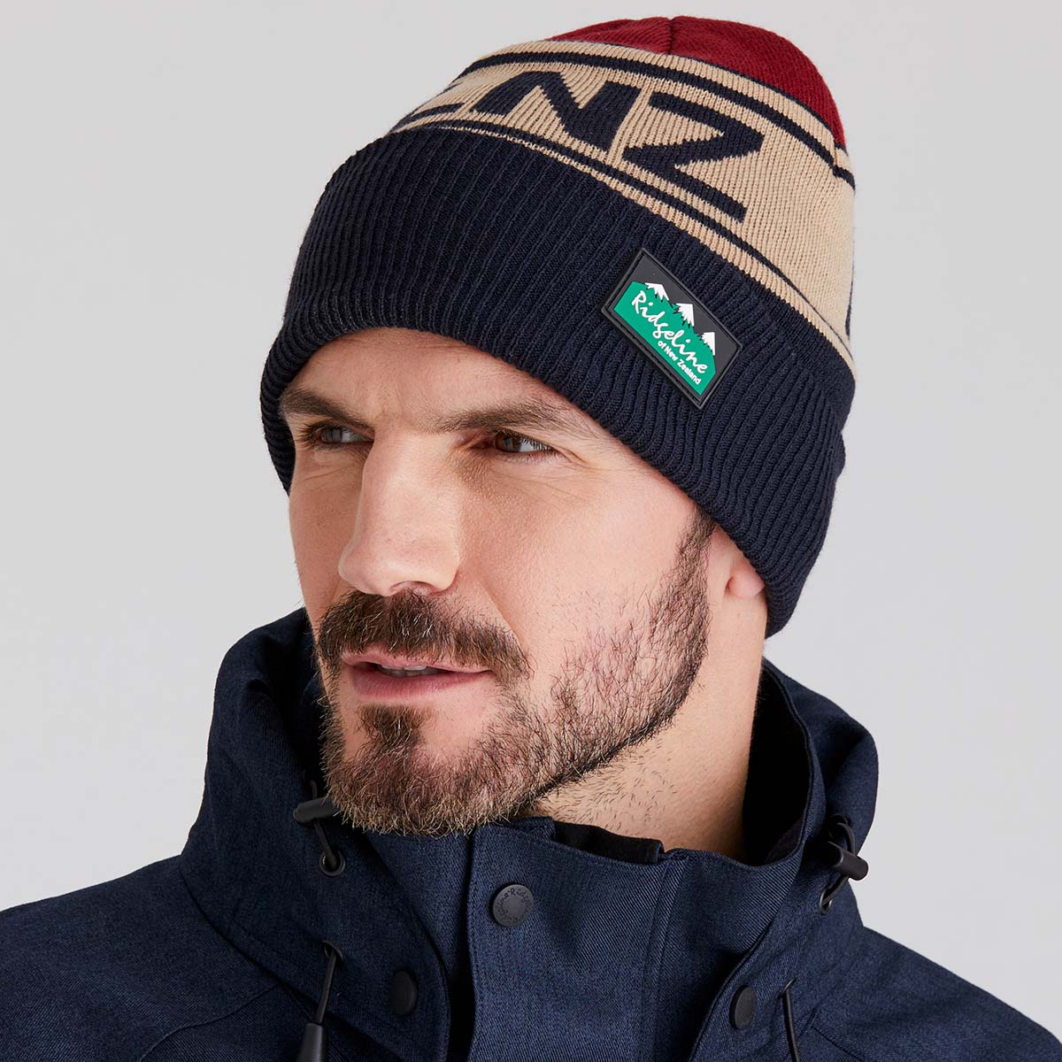 Man wearing a beanie with 'RLNZ' branding against a plain background