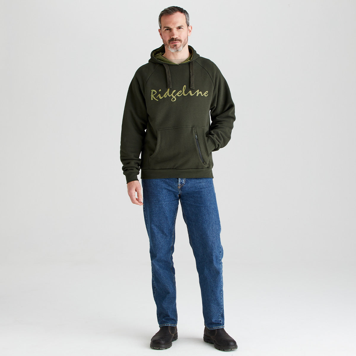 Man wearing a green hoodie with 'Ridgeline' logo and blue jeans on a white background