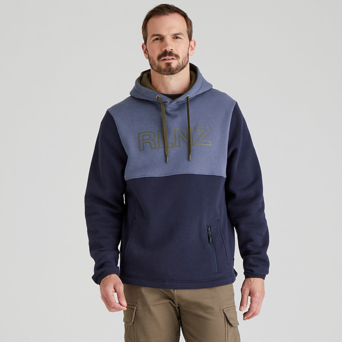 Man wearing a two-tone blue hoodie with 'RLNZ' branding on a grey background