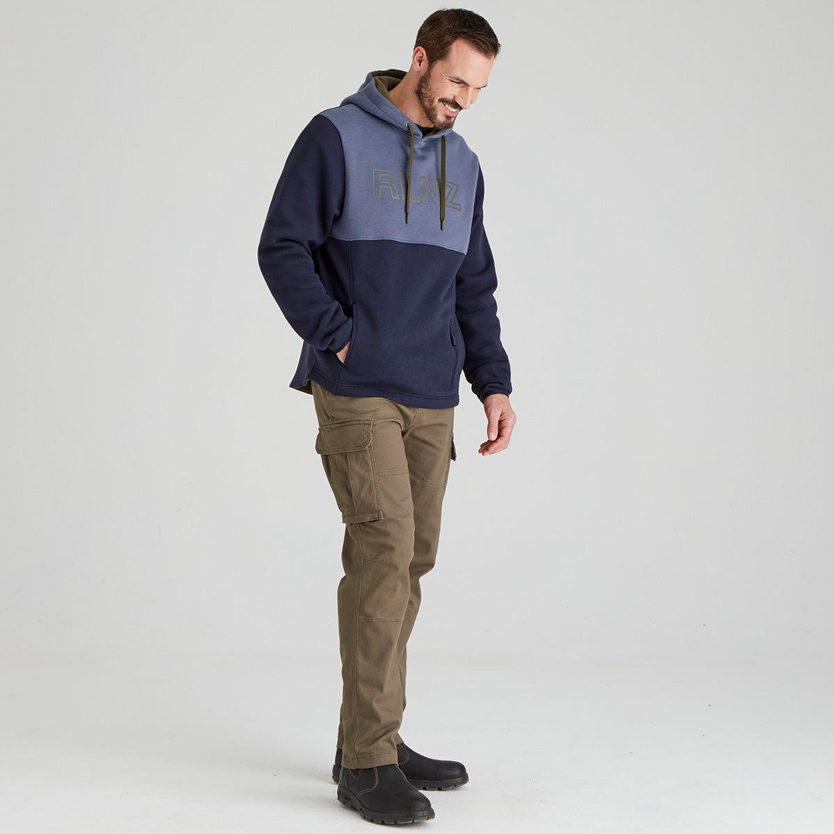 Man wearing a two-tone hoodie and cargo pants on a white background