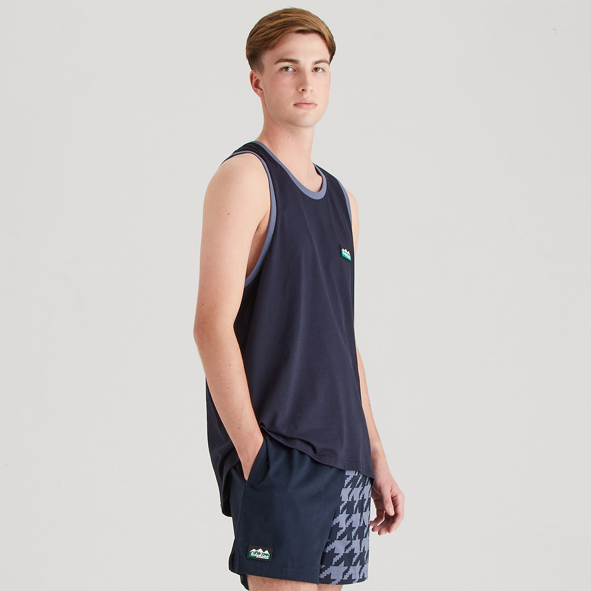 Person wearing a navy sleeveless sports top and shorts on a light gray background