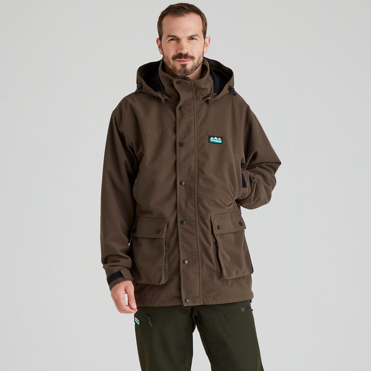 Man wearing a brown waterproof jacket with a Ridgeline Clothing brand logo on a grey background