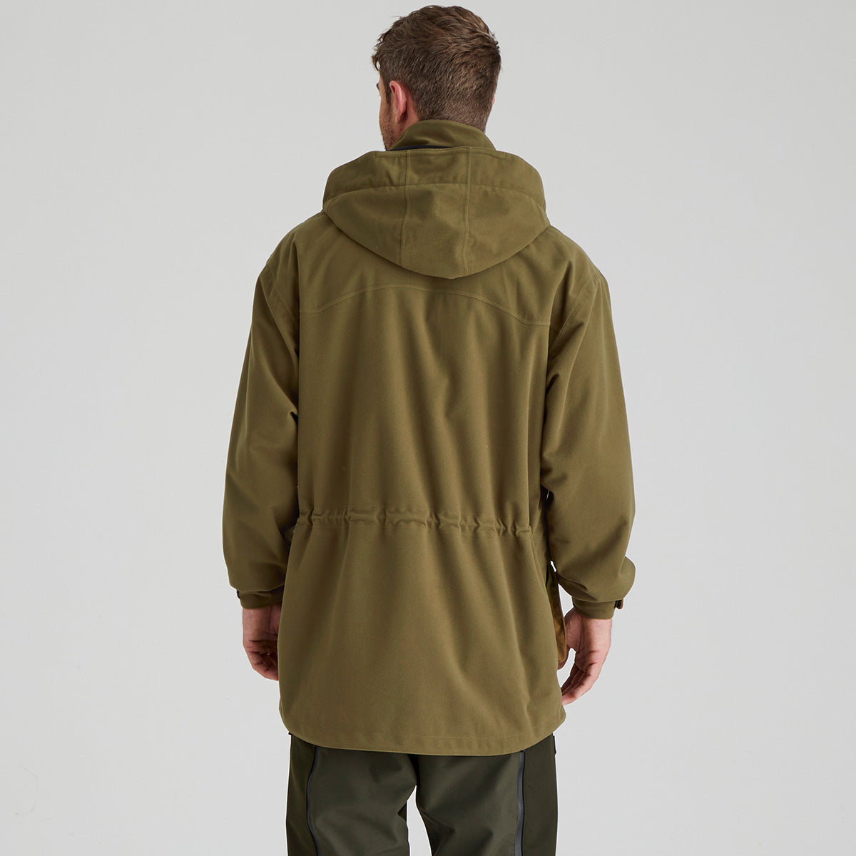 Back of person wearing a green jacket on a light grey background