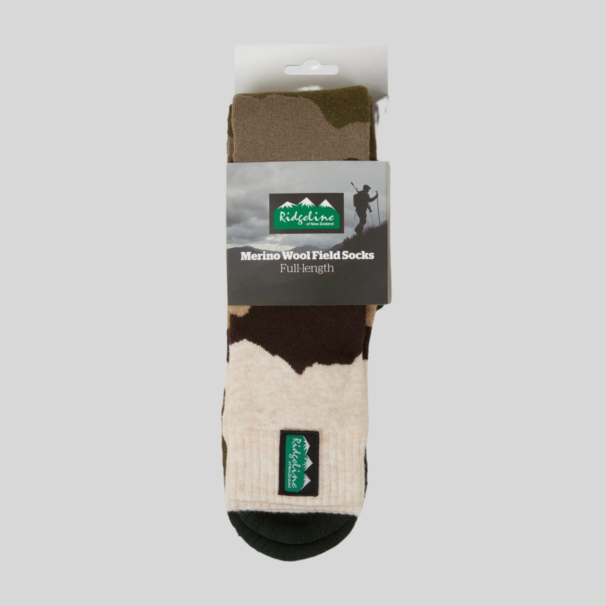 A camouflage patterned full-length merino wool sock with a visible Ridgeline Clothing brand logo. In its packaging