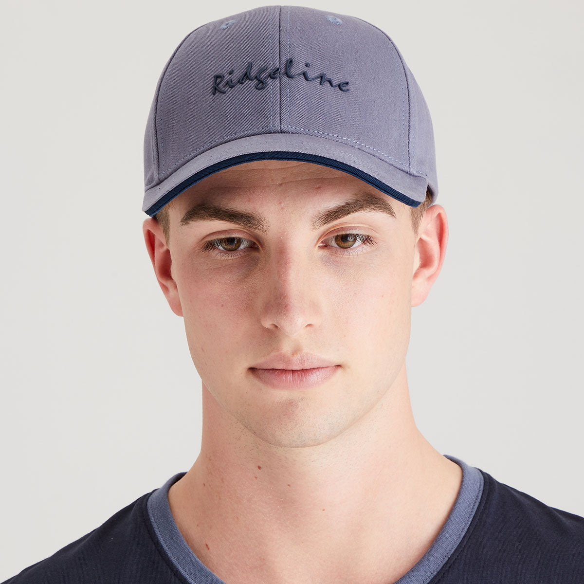 Man wearing a light blue cap with 'Ridgeline' branding on a light grey background